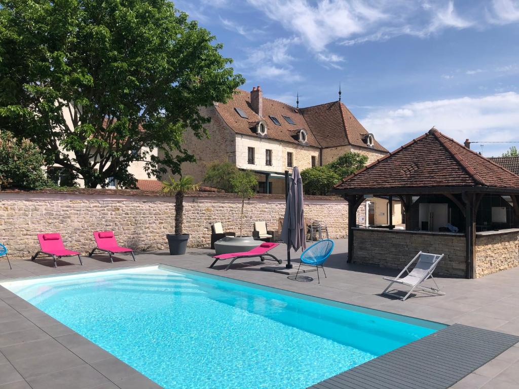 einen Pool mit Stühlen und einem Pavillon in der Unterkunft Logis L'Hôtel D'Arc in Arc-sur-Tille