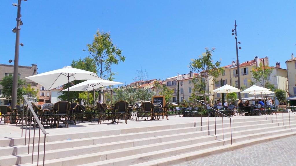 a seating area with tables and chairs and umbrellas at Hotel Relais Du Postillon in Antibes