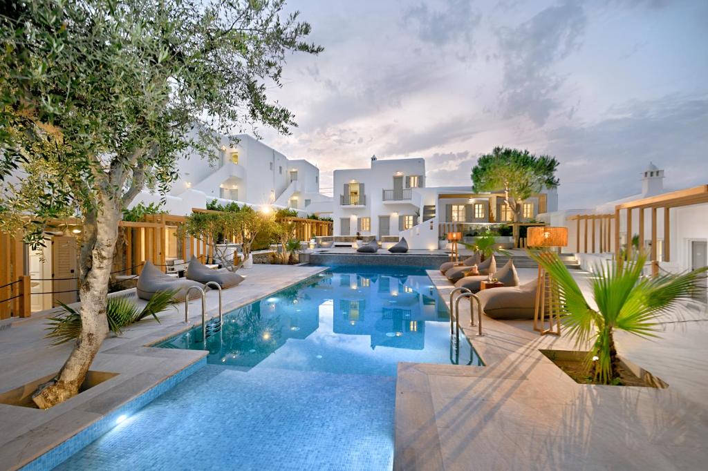 - une piscine avec des chaises et une maison dans l'établissement Petinos Hotel, à Platis Gialos