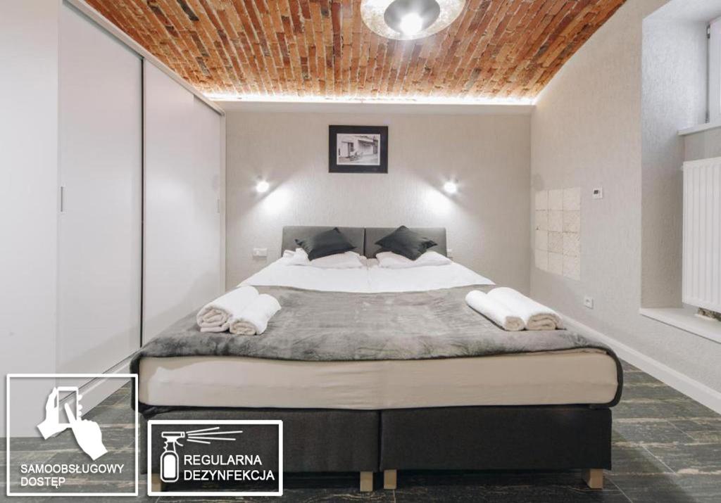 a bedroom with a large bed with a wooden ceiling at Platan Apartments-Cosy and unique-Studio- big bed in Krakow