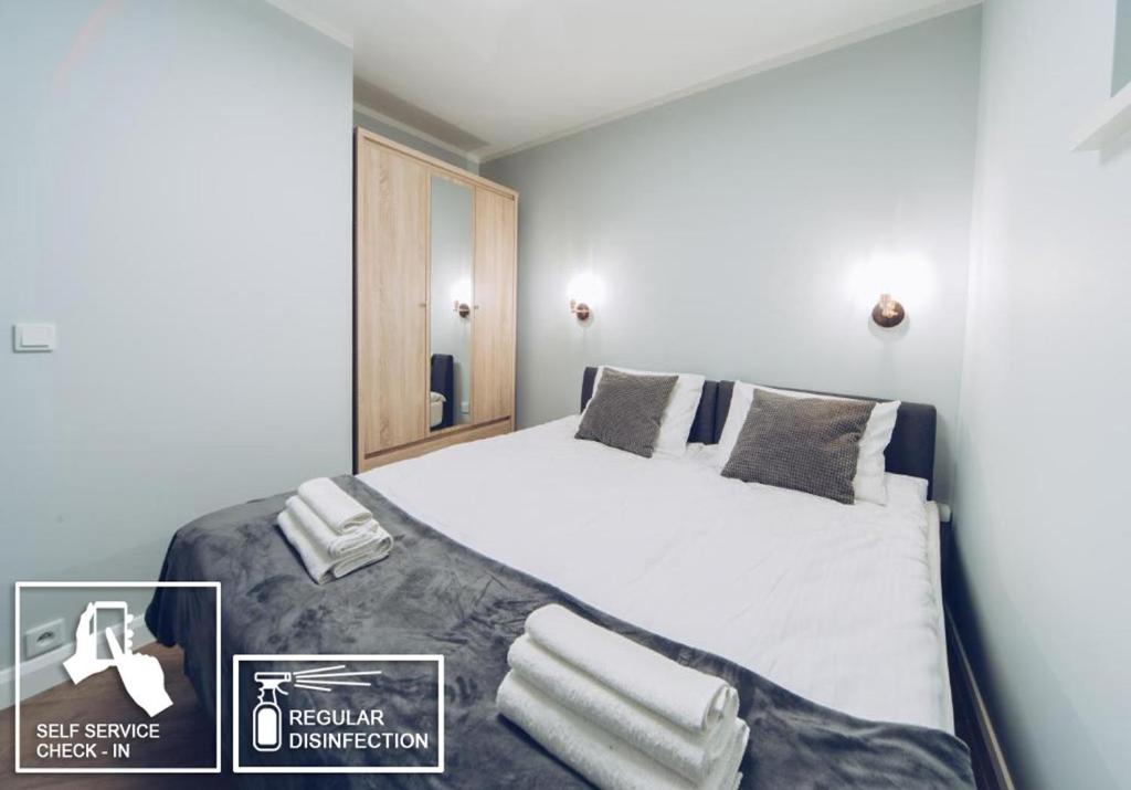 een slaapkamer met een groot bed met witte lakens en kussens bij Platan Apartments-2 bedrooms-3 min Main Squer in Krakau