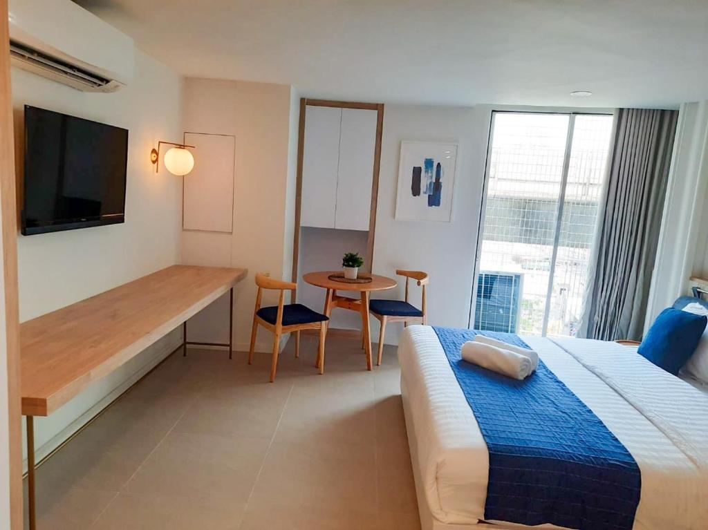 This angle shows the double bed beside a two-seat table and a wall-length console.