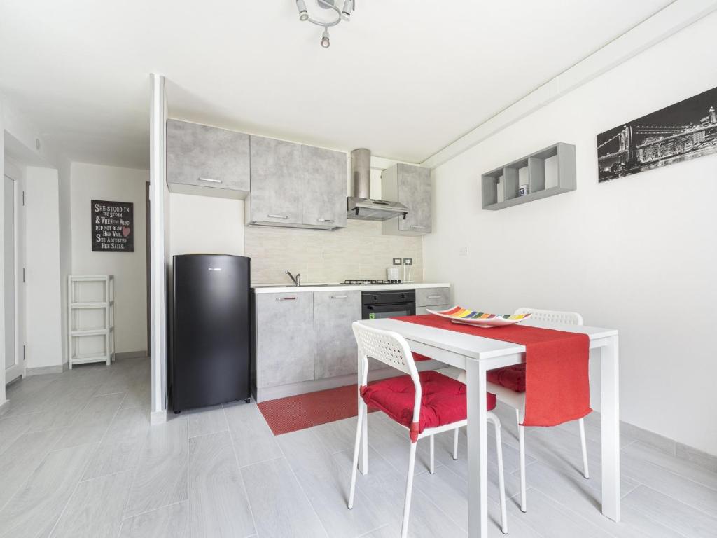 una cucina con tavolo, sedie e frigorifero di Appartamento Ai Crocus a Cesclans