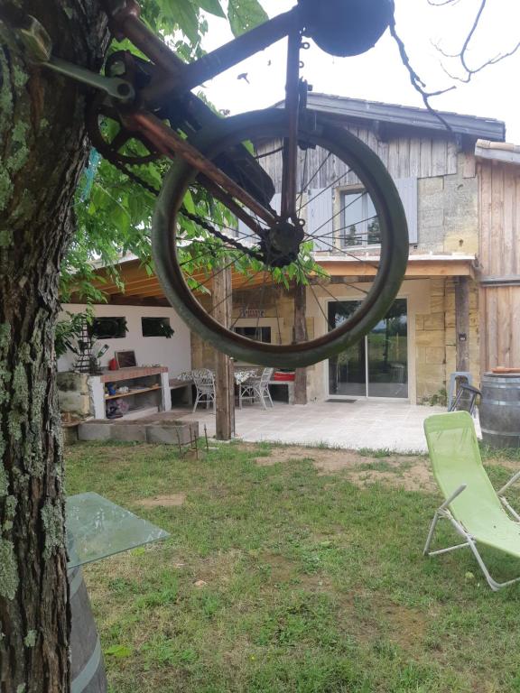 Saint-Sulpice-de-Faleyrens的住宿－Au Vélo dans l'Arbre，挂在房子前面的树上的自行车