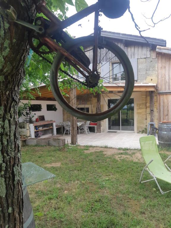 a bike hanging from a tree in front of a house at Au Vélo dans l'Arbre in Saint-Sulpice-de-Faleyrens