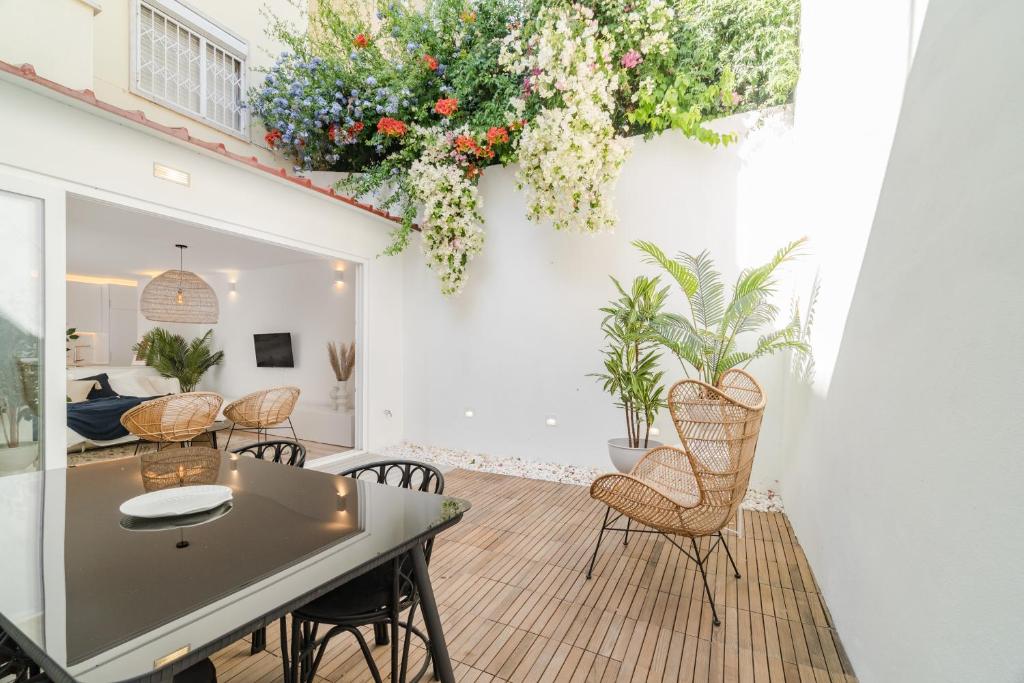 a living room with a table and chairs and flowers at Casa Boma Lisboa - Architect Apartment with Private Terrace - Alcantara III in Lisbon