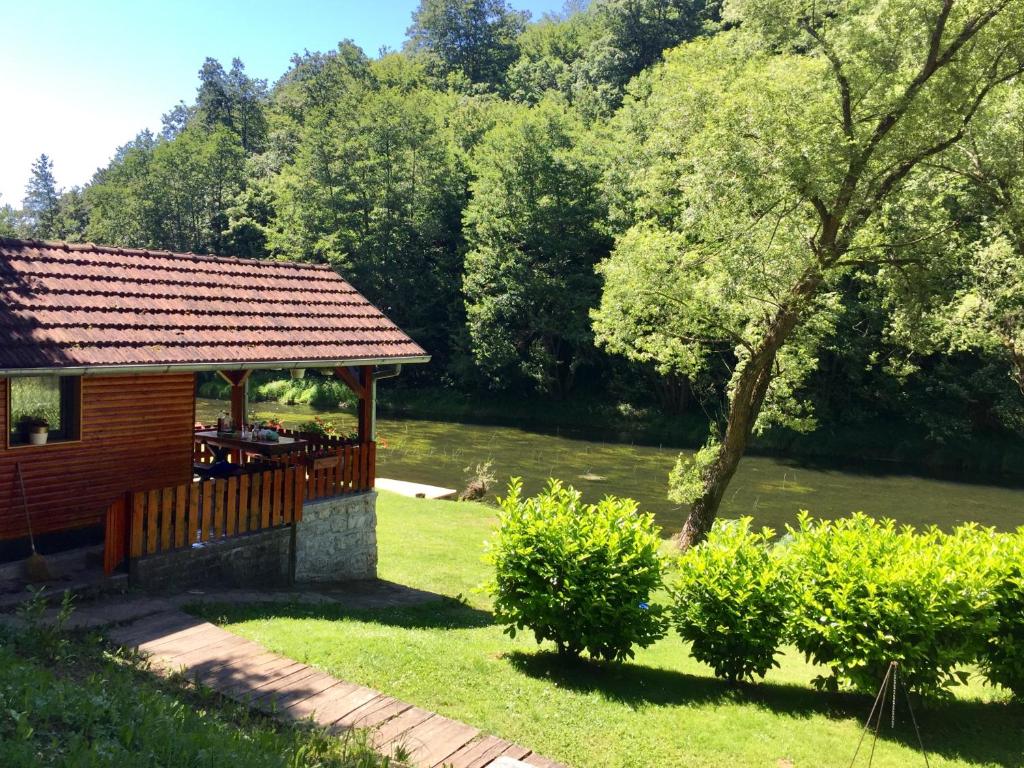 eine Holzhütte mit einer Terrasse im Hof in der Unterkunft Holiday Home Radočaj in Slunj