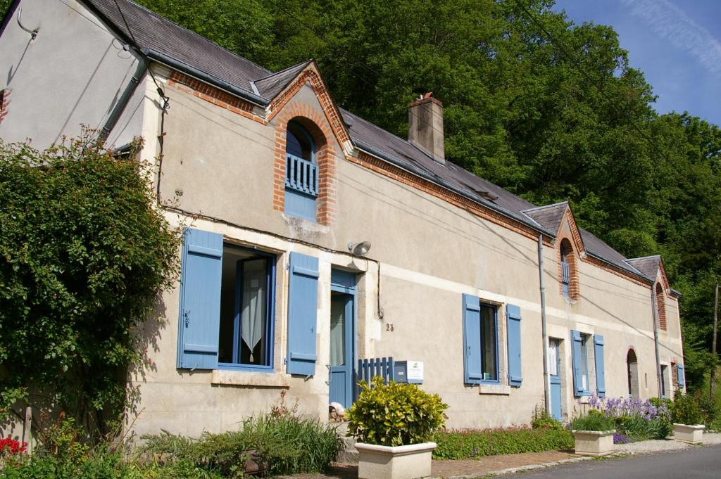 an old house with blue shutters on a street at La Source de Bury in Chambon-sur-Cisse