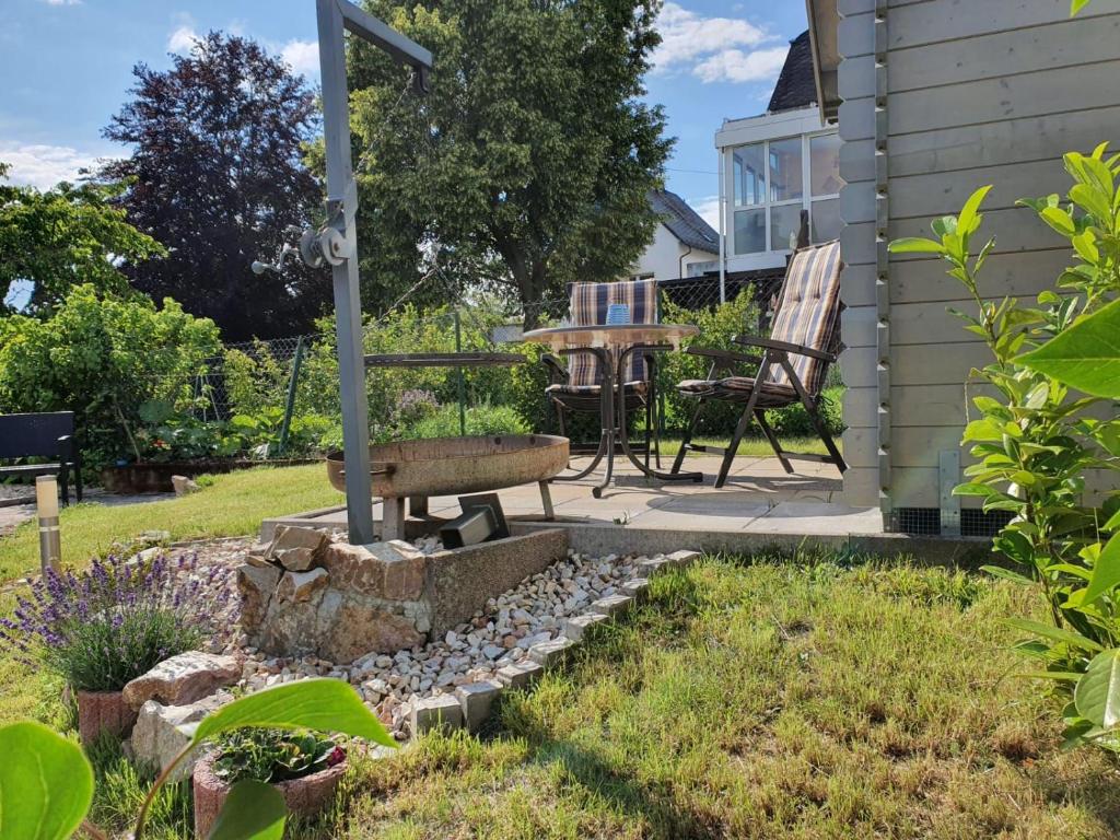 un jardín con banco, mesa y sillas en FeWo Algenrodt, en Idar-Oberstein