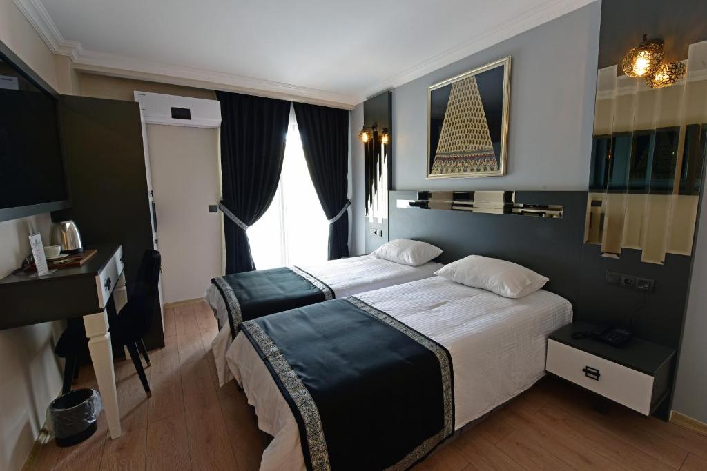 a bedroom with a large bed and a desk at Hotel Sultansaray Sultanhanı in Sultanhanı