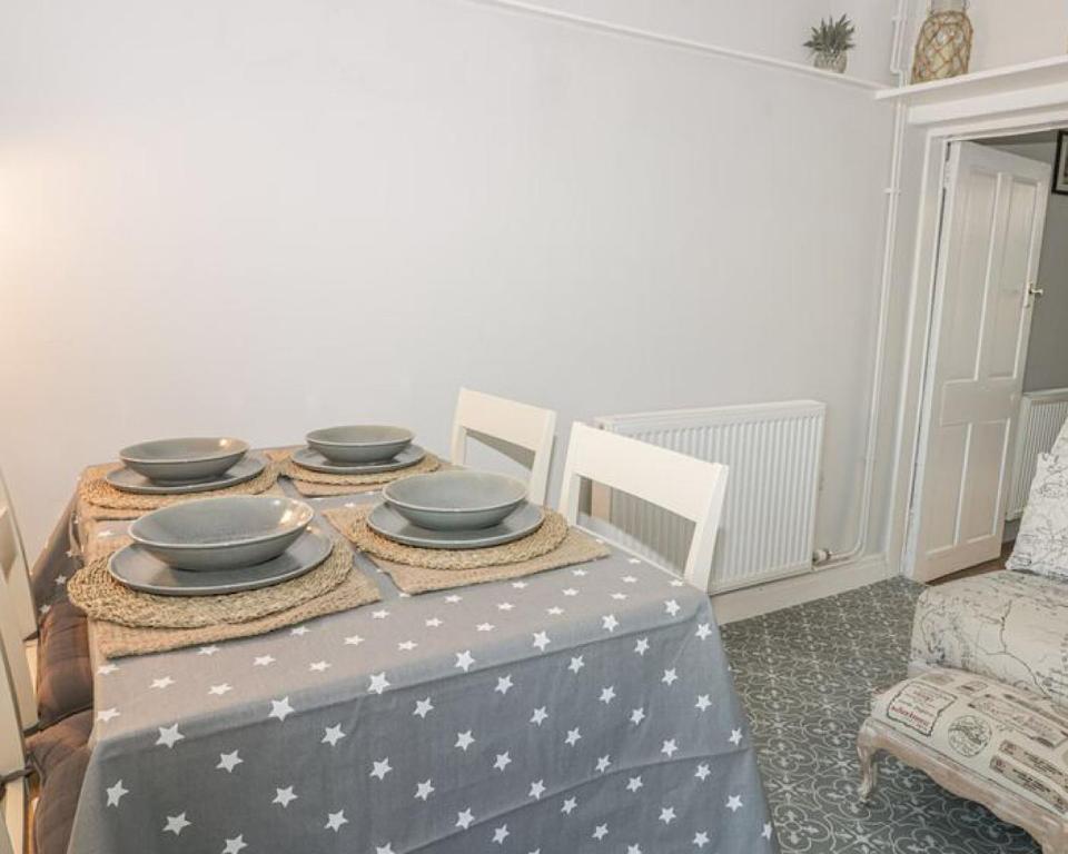 uma mesa com tigelas e pratos por cima em Captains Cottage em Scarborough