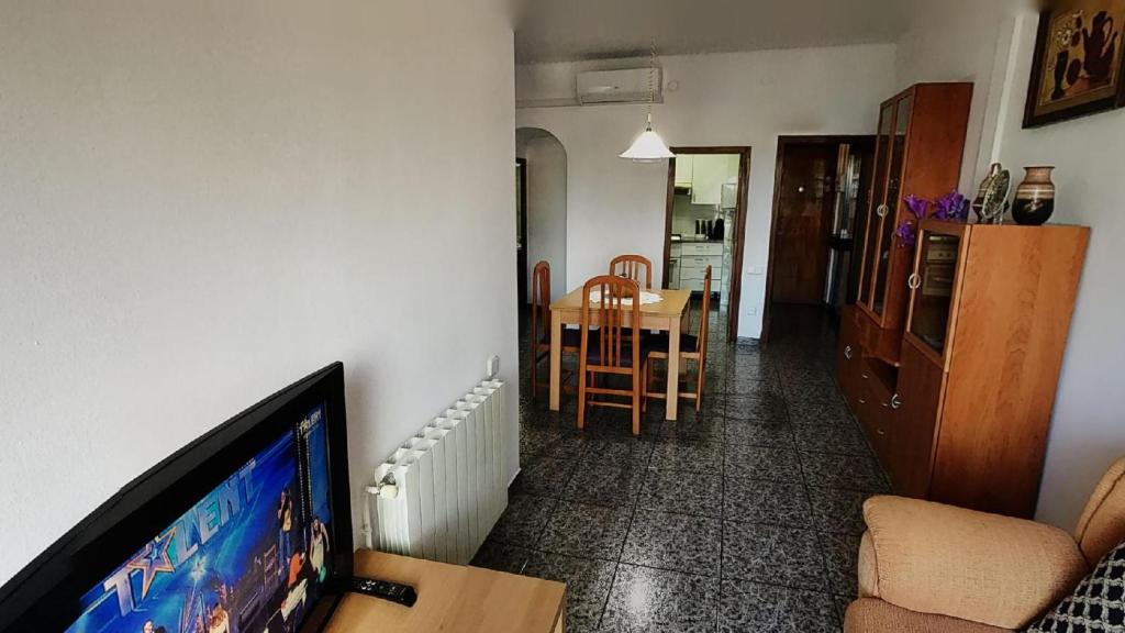 a living room with a flat screen tv and a table at Near Maresme Forum Apartment in Barcelona