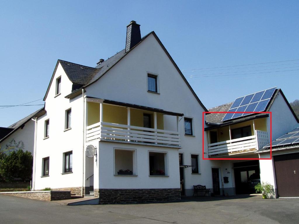a white house with solar panels on the roof at Weinhaus Lenartz-Bleser in Briedern