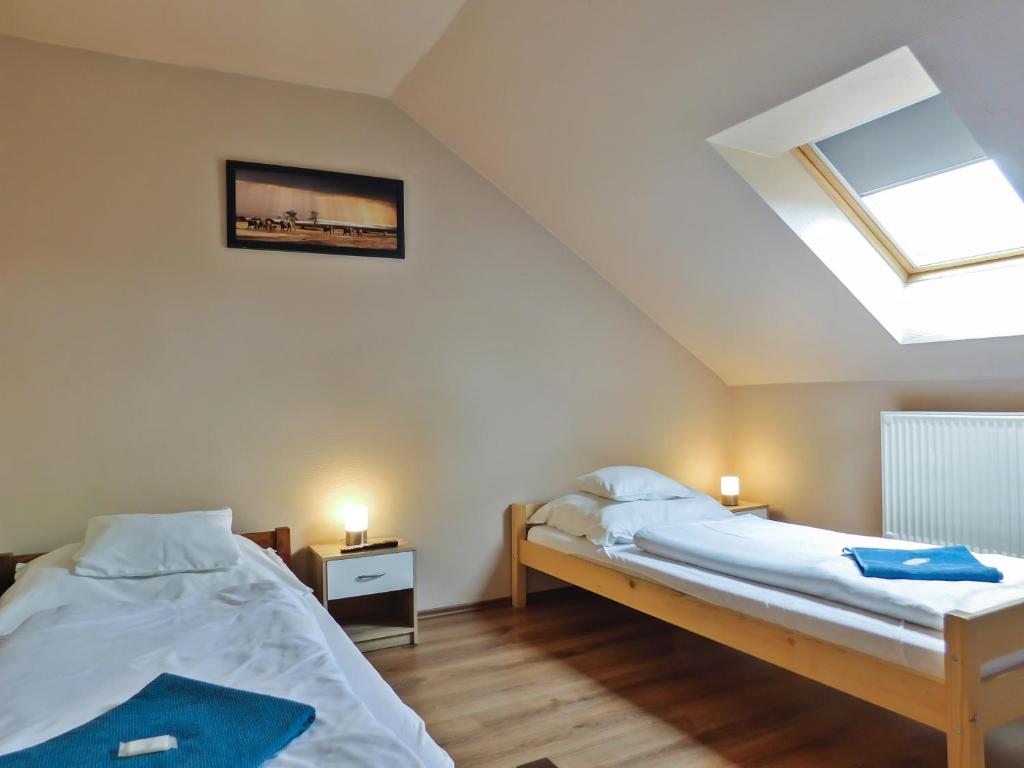 a bedroom with two beds and a skylight at Korona Panzió in Levél