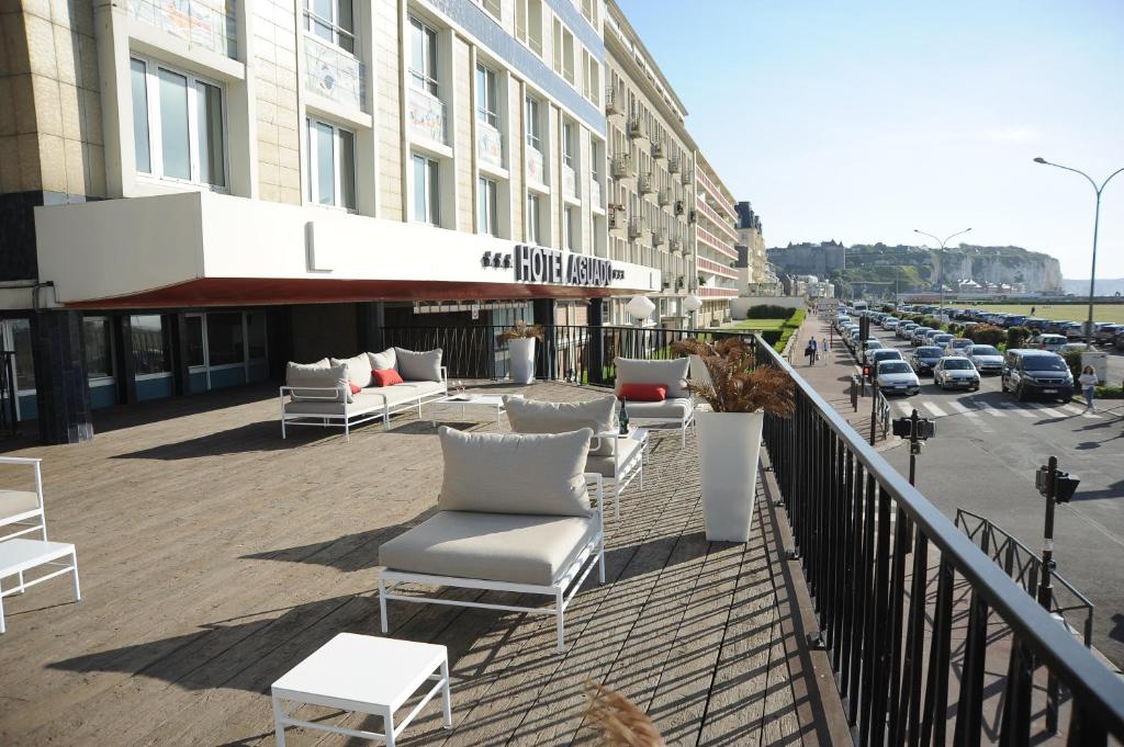 a balcony with chairs and tables on a city street at Hotel Aguado in Dieppe