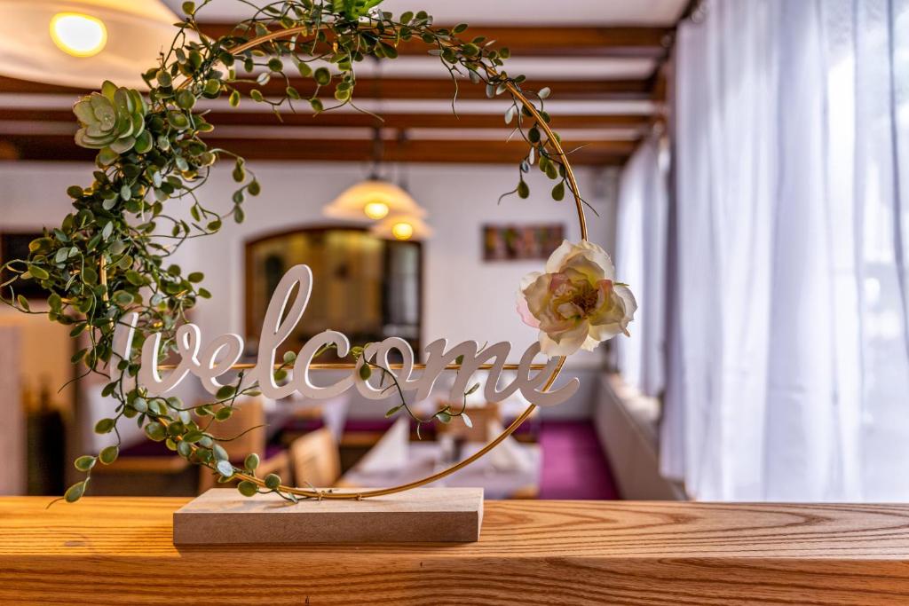 een bord op een tafel met bloemen erop bij Hotel Casa Maria in Halblech
