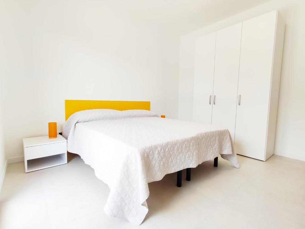 Dormitorio blanco con cama blanca y mesa en QUITO - Dietro Piazza Mazzini - Immobil Relax, en Lido di Jesolo