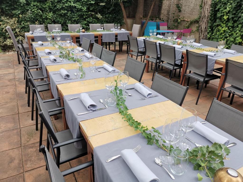 un ensemble de tables avec des serviettes blanches et des vignes vertes dans l'établissement Cal Duran, à Esparraguera