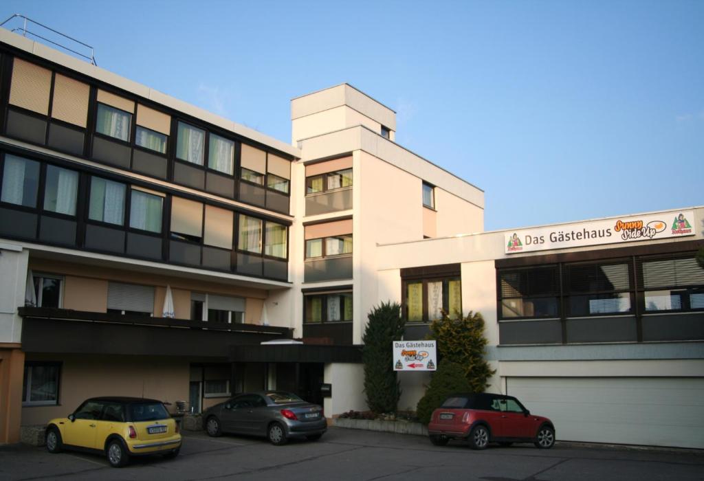 two cars parked in front of a building at Hotel Sunny Side Up in Dauchingen