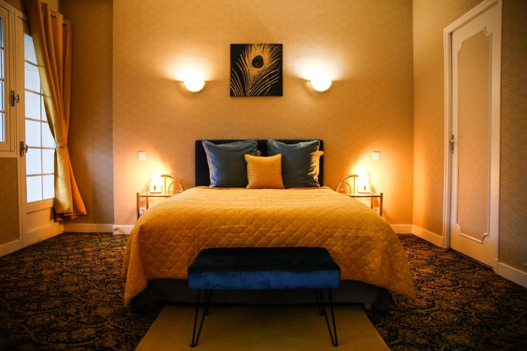 1 dormitorio con 1 cama y 2 luces en la pared en Aux Portes du Château, en Valençay
