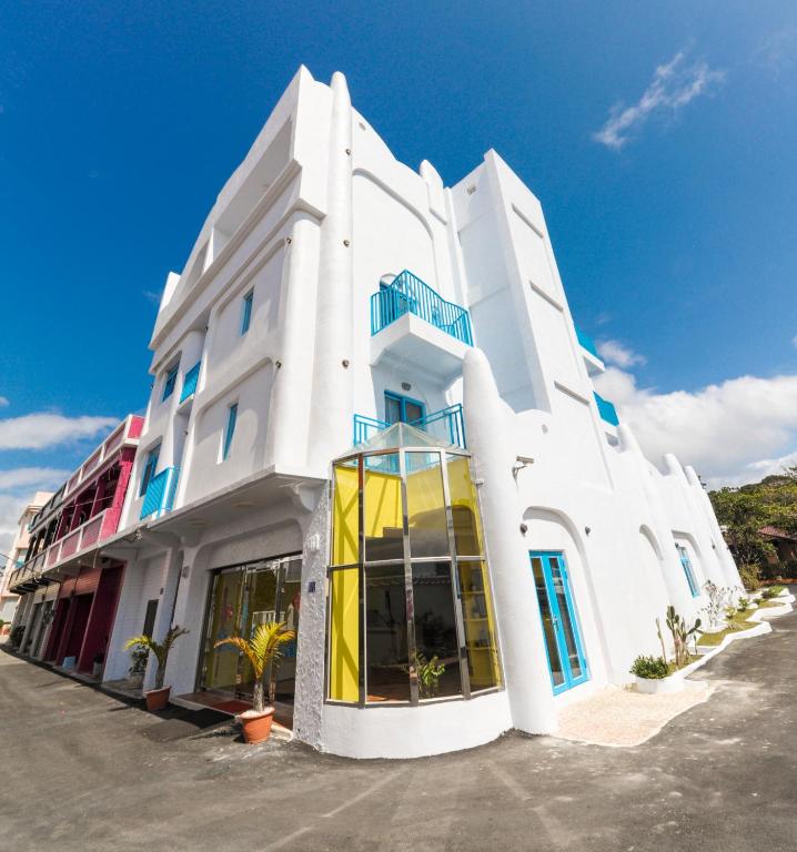 a white building with yellow doors on a street at Kenting Shen&#39;s Homestay in Eluan