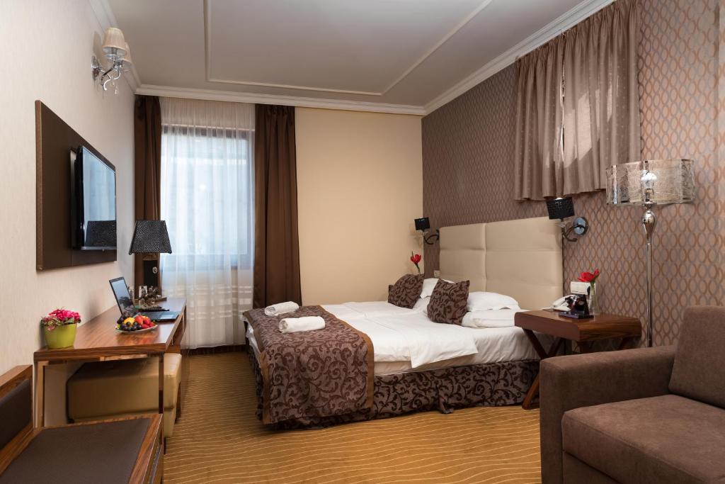 pokój hotelowy z łóżkiem i kanapą w obiekcie Golden Ball Club w Győr