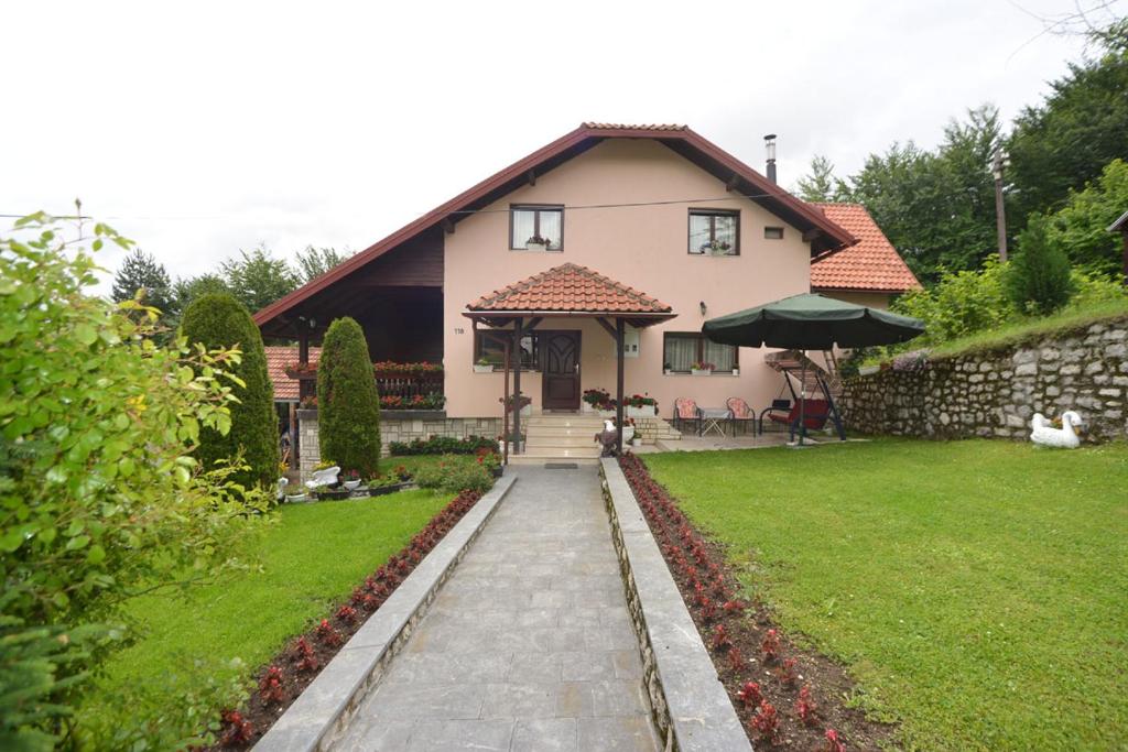 ein Haus mit einer Steinmauer und einem Hof in der Unterkunft Apartment Vihor in Zlatibor