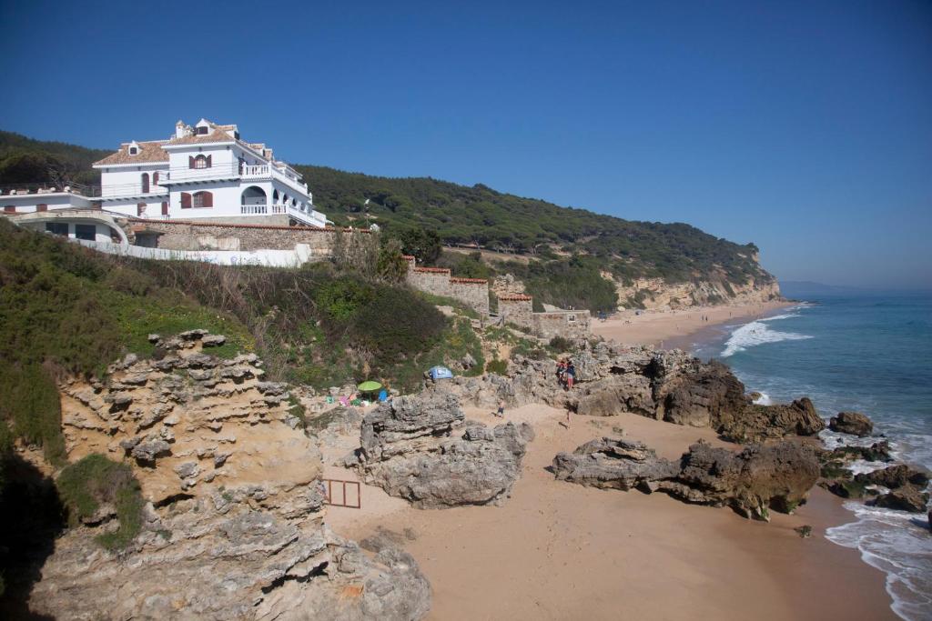 ein Haus auf einer Klippe am Meer in der Unterkunft Hostal Mar de Frente in Los Caños de Meca