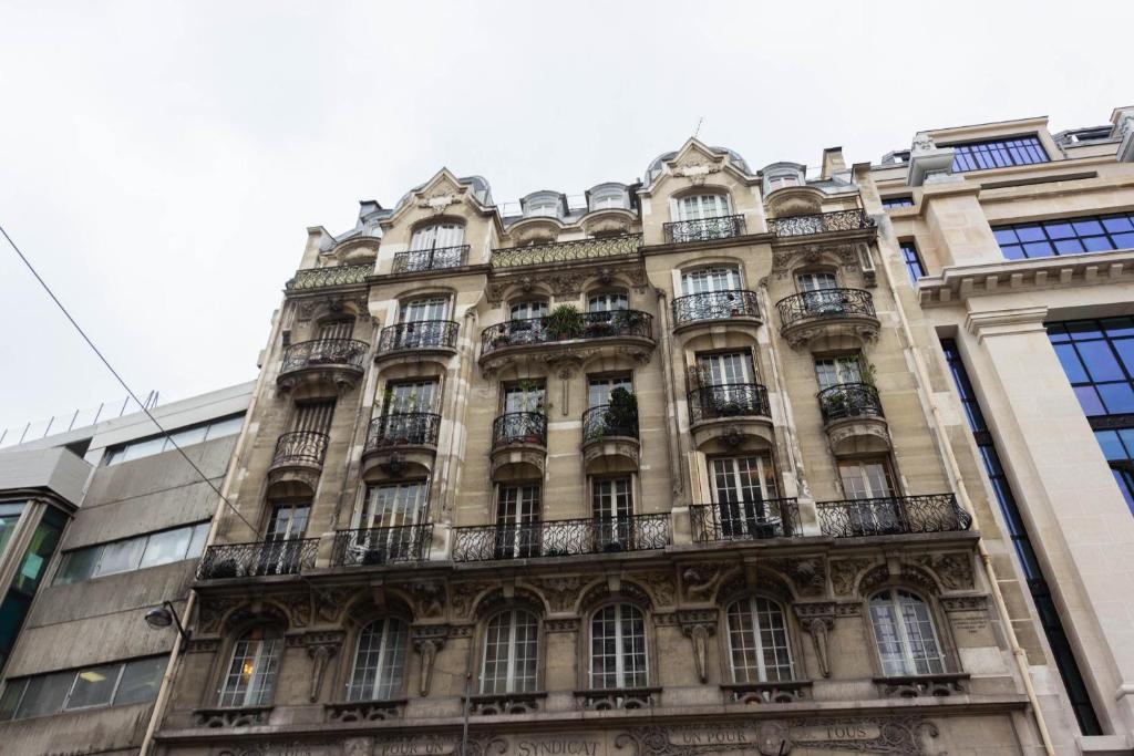 a tall building with balconies on the side of it at Marais Renard in Paris