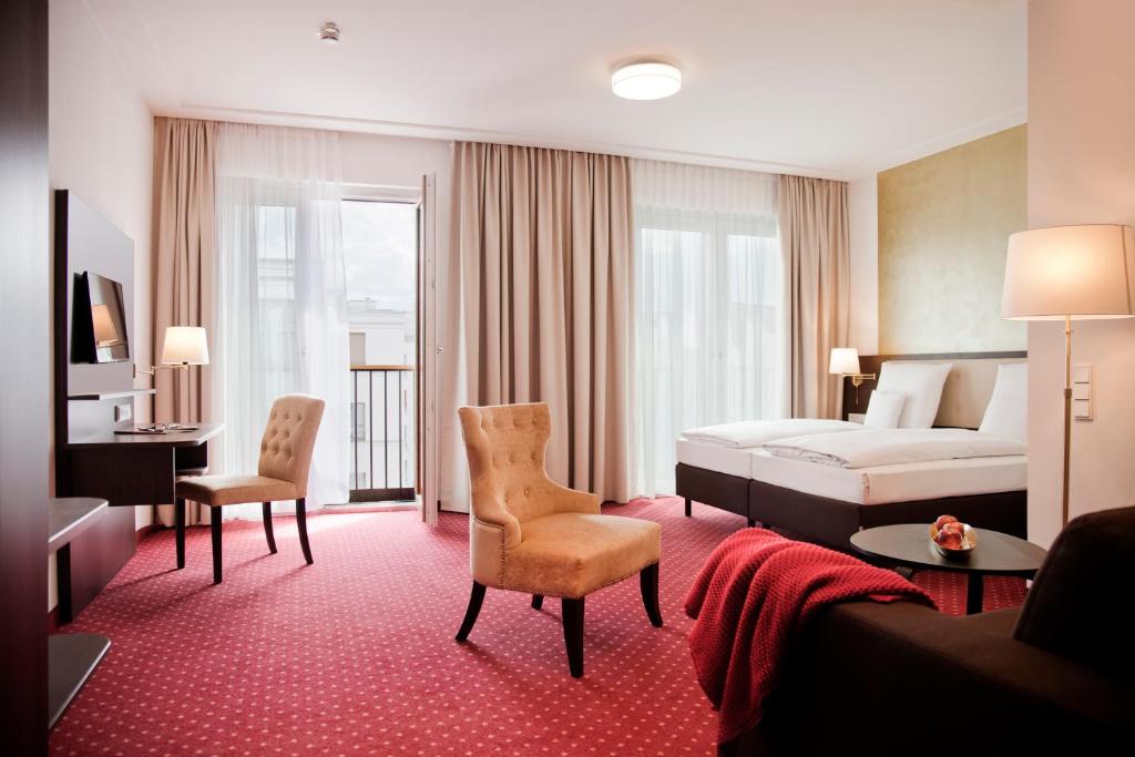 a hotel room with a bed and a living room at Gold Palais Hotel in Berlin