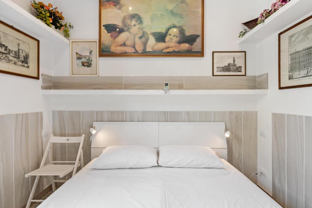 1 dormitorio con 1 cama blanca y 1 silla en Guest House Biffi Simone, en Florencia