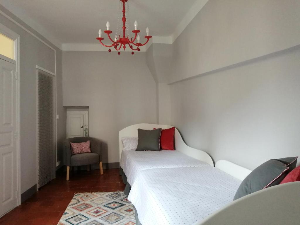 een slaapkamer met 2 bedden en een kroonluchter bij Apartamento Torreón de la Bombardera in Teruel