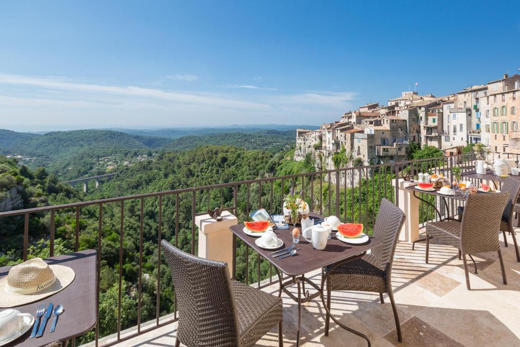 a table and chairs on a balcony with a view at Histoires de Bastide in Tourrettes-sur-Loup