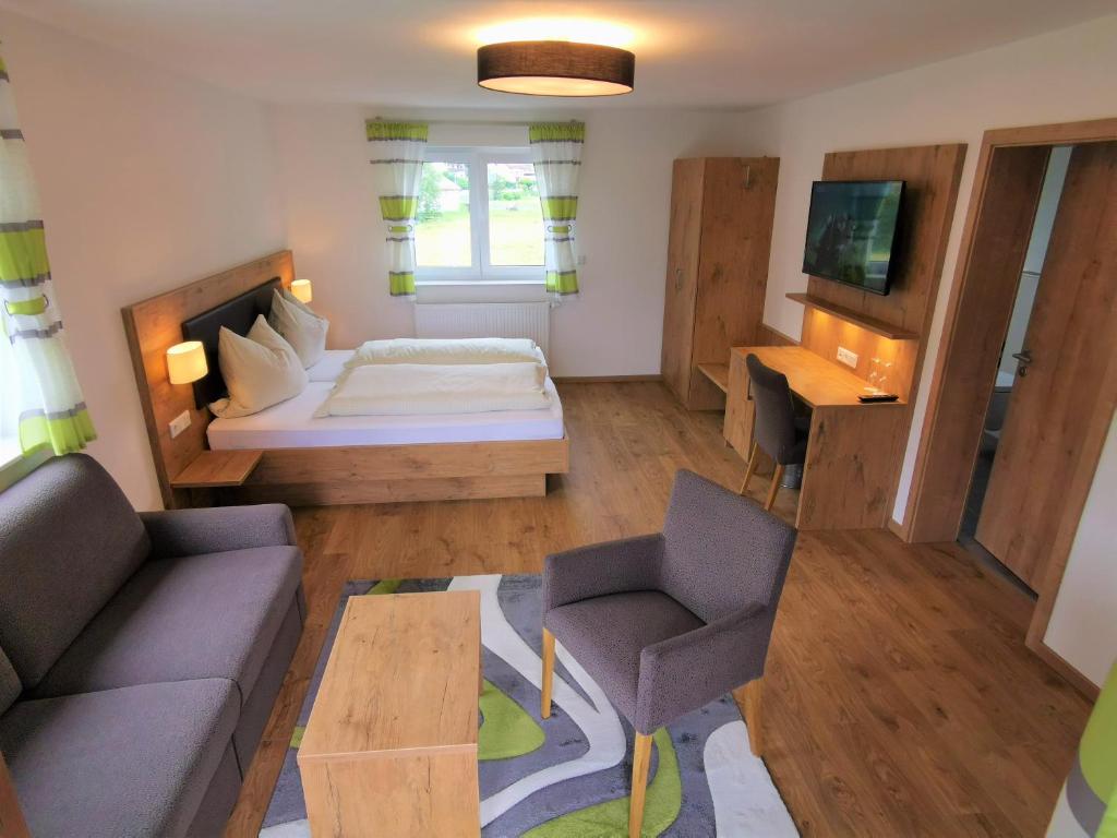 uma pequena sala de estar com uma cama e um sofá em Hotel Grüner Baum mit Restaurant & Wellness em Beerfelden