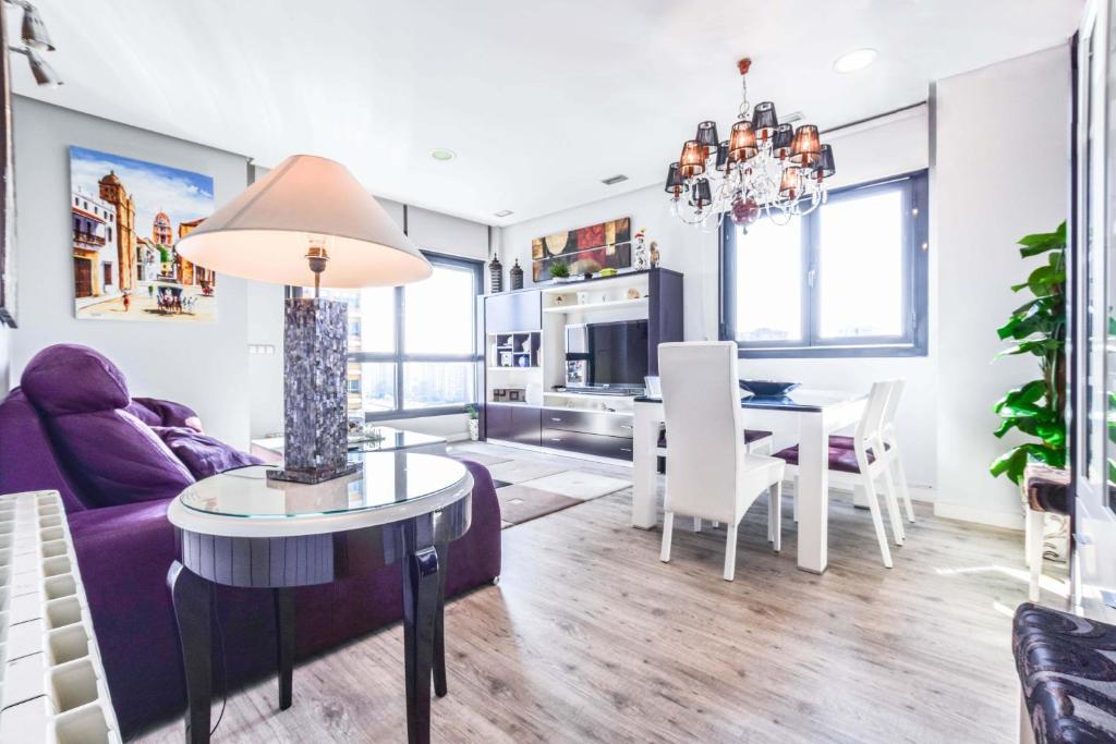 マドリードにあるBonito piso luminoso en urbanización de lujoの紫色のソファとテーブル付きのリビングルーム