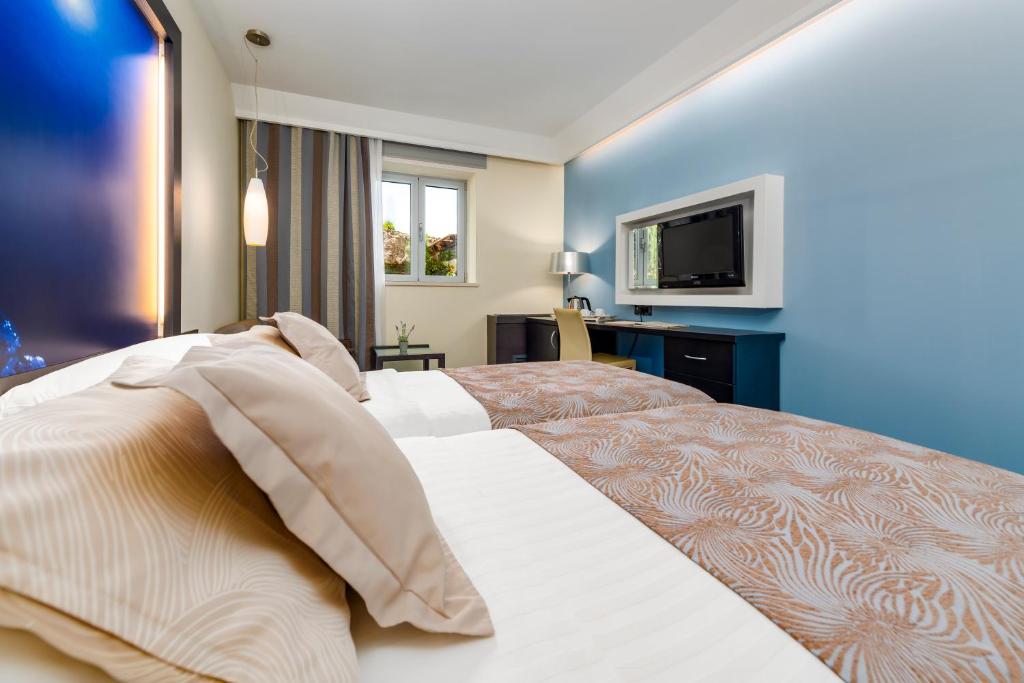 Postel nebo postele na pokoji v ubytování Hotel Lapad