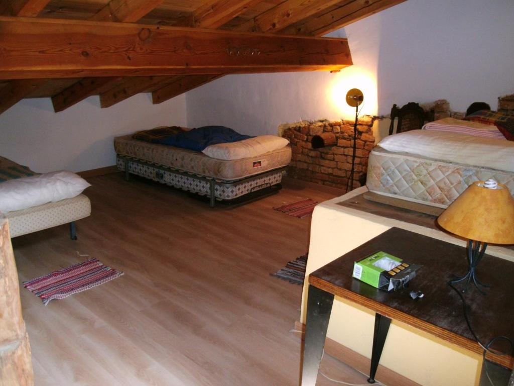 Sala de estar con 2 camas y mesa en Albergue el Hacedor, en La Aldea del Portillo de Busto