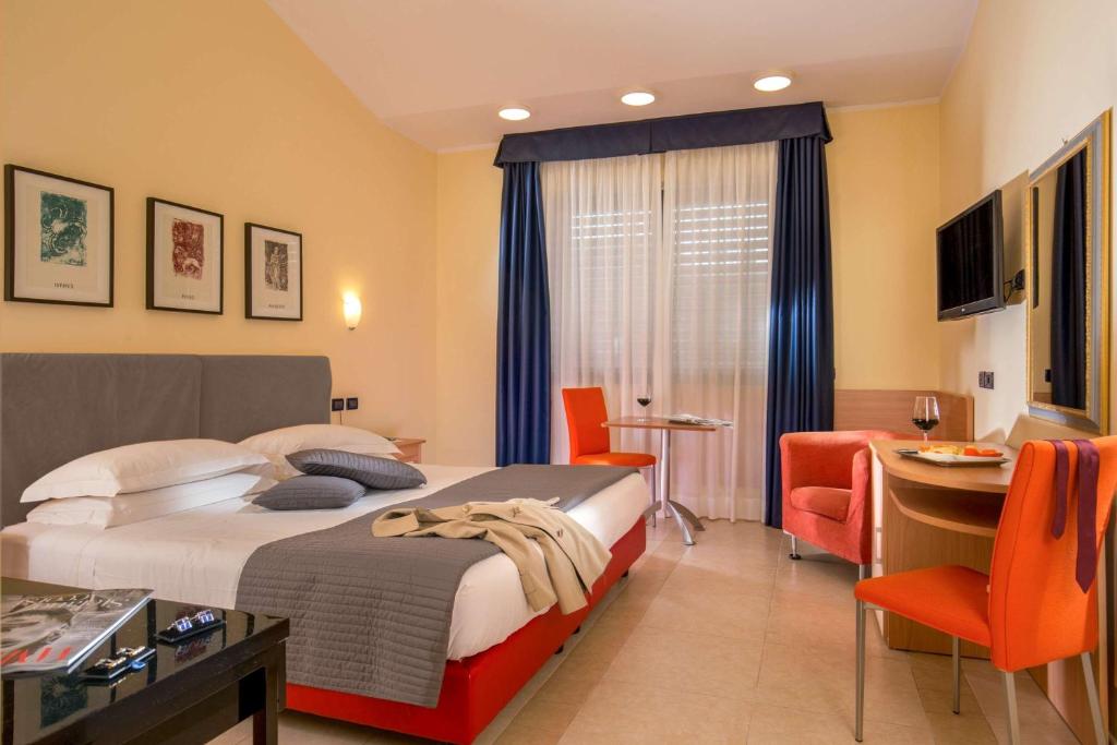 um quarto de hotel com uma cama, uma mesa e cadeiras em Best Western Blu Hotel Roma em Roma