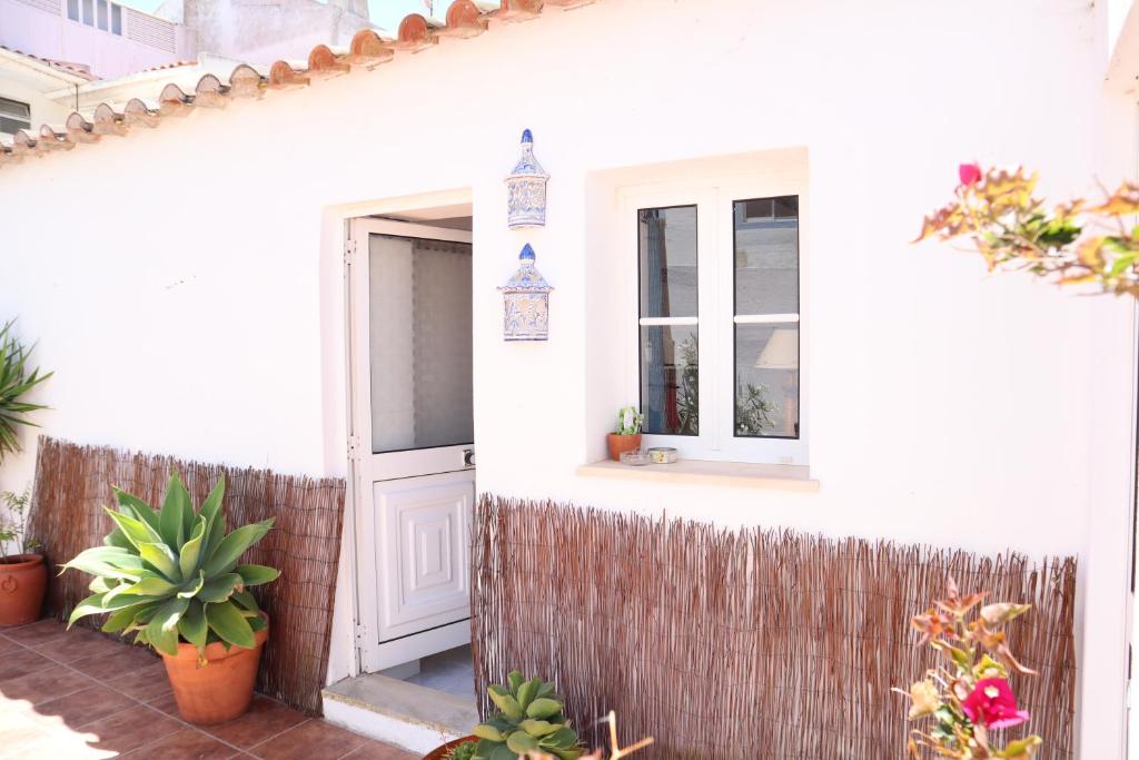 a white house with a door and some plants at Salema Beach Private Villa in Salema