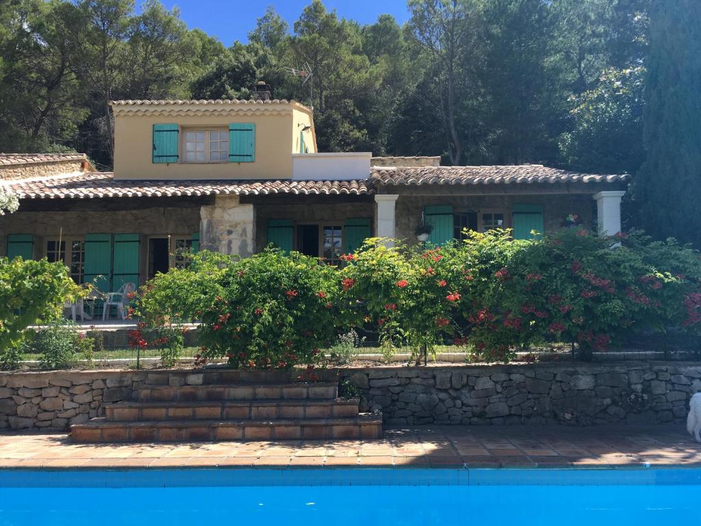 une maison à côté d'une piscine fleurie dans l'établissement Mas de la Pinède ex-Les Arbousiers, à Bollène