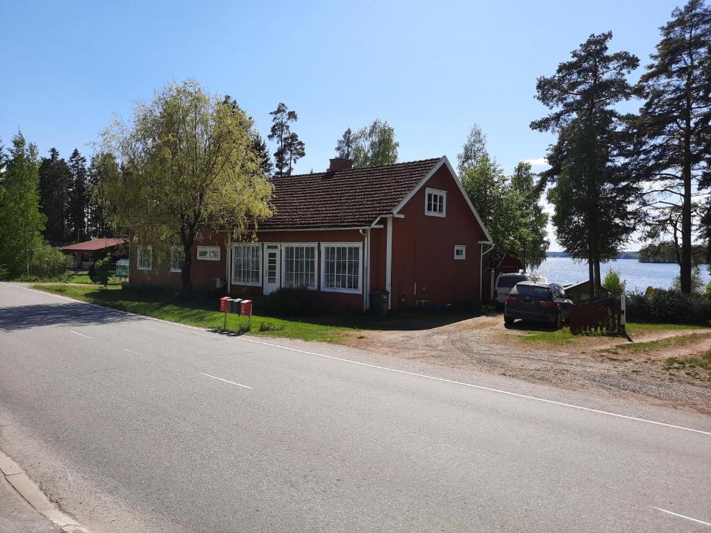 a red house on the side of a road at Punavilla majoitus TASANKO in Säkylä
