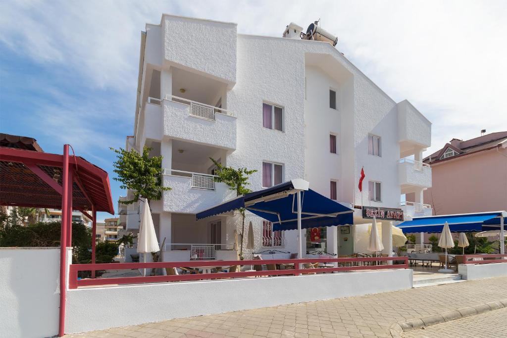 a white building with blue umbrellas in front of it at Sezin Apart in Marmaris
