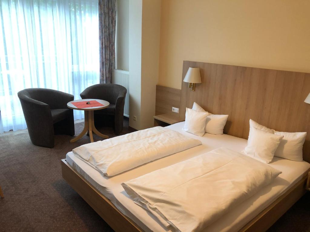 シュトックアッハにあるHotel Fortunaのベッド、テーブル、椅子が備わるホテルルームです。