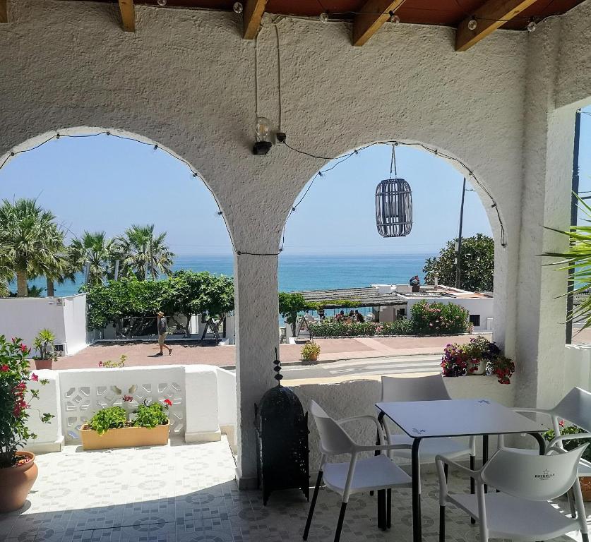 eine Terrasse mit einem Tisch, Stühlen und Meerblick in der Unterkunft Casaflor in Mojácar