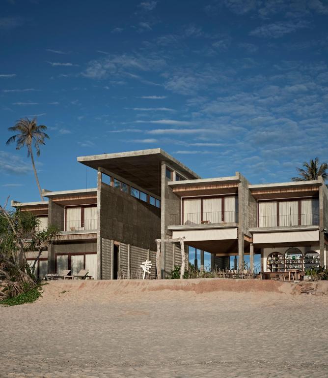 ein Haus am Strand mit einer Palme in der Unterkunft Chula Beach Resort in Khanom