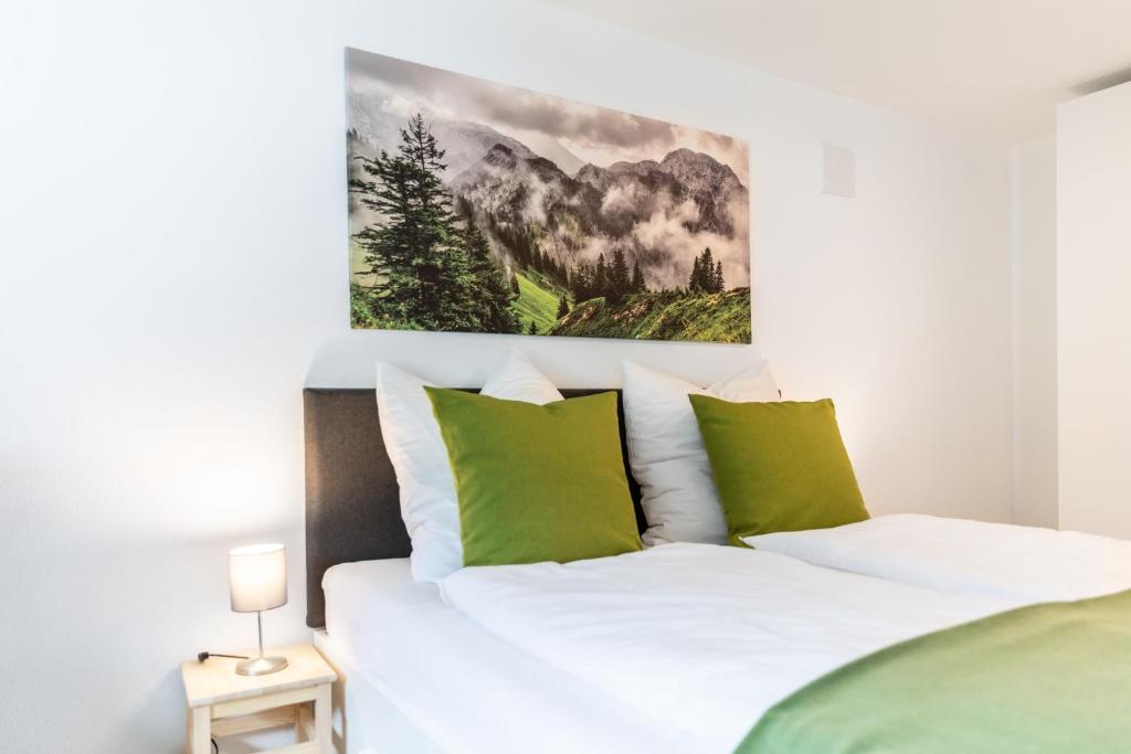 a bedroom with a bed with green and white pillows at Chalet Annemarie Hohenschwangau in Hohenschwangau