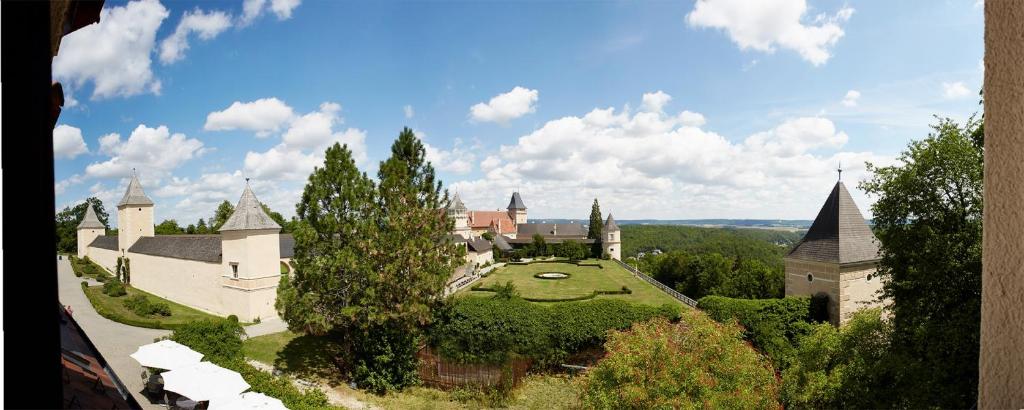 ein altes Schloss mit einem grünen Hof und Bäumen in der Unterkunft Schlossgasthof & Hotel Rosenburg in Rosenburg