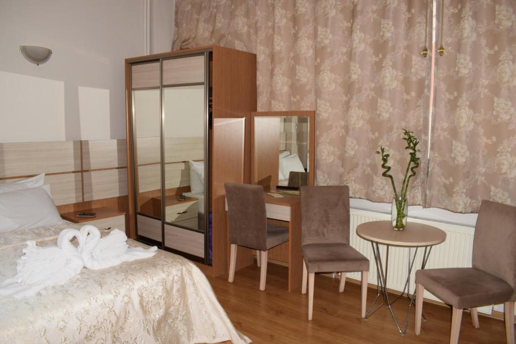 een slaapkamer met een bed en een tafel en stoelen bij Royal Suites Besiktas in Istanbul