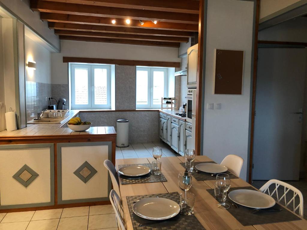 a kitchen with a wooden table with chairs and a dining room at L’Ecrin champenois : 150m2 au cœur du vignoble in Étoges