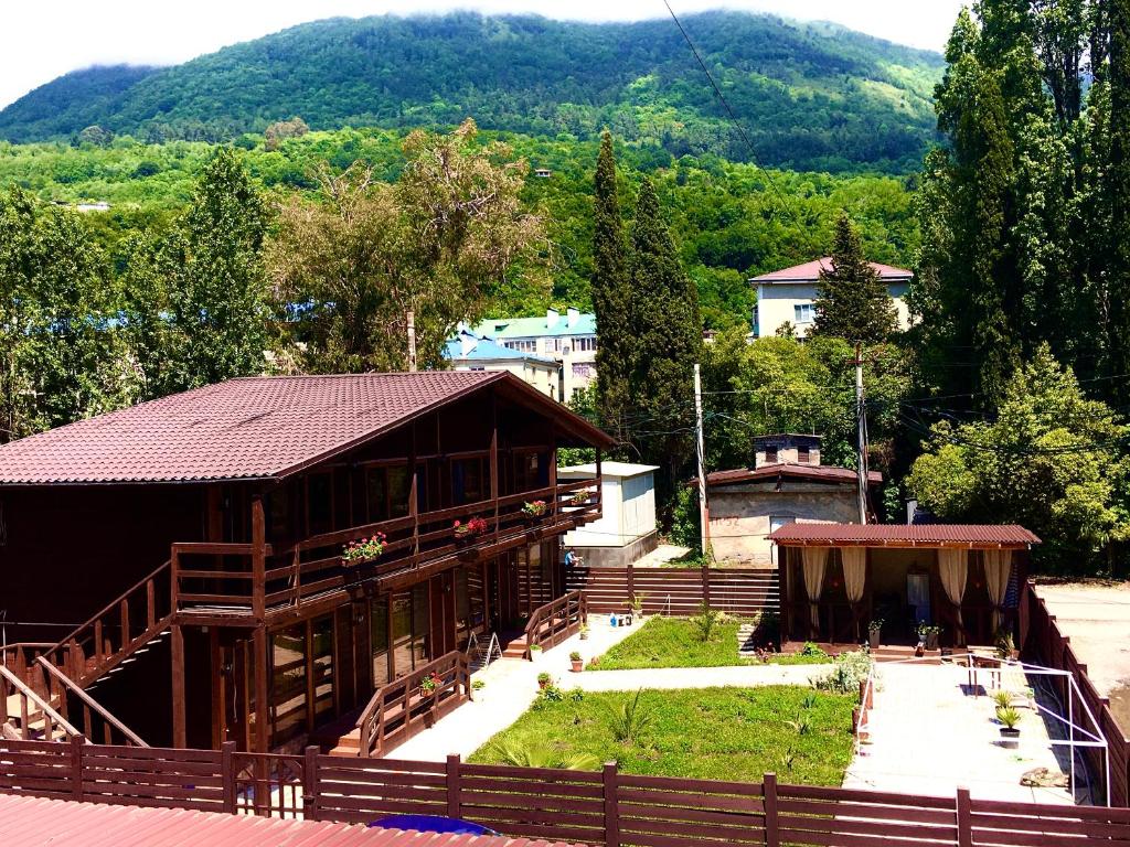 a building with a garden in front of it at Гостевой дом "OSCAR" in Gagra